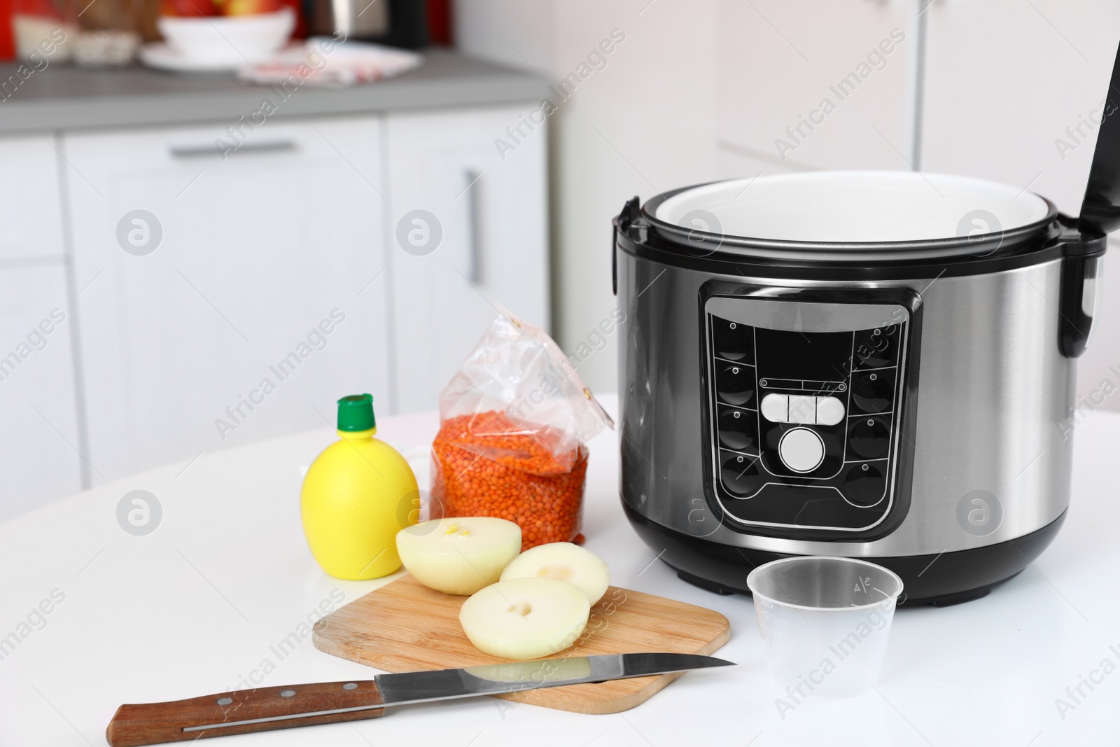 Photo of New modern multi cooker and products on table in kitchen. Space for text