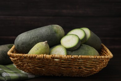 Photo of Green daikon radishes in wicker basket on wooden table