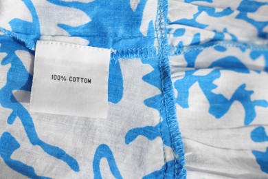 Clothing label on color garment, closeup view