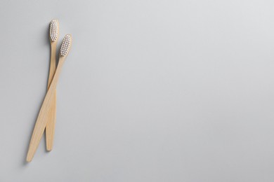 Photo of Bamboo toothbrushes on white background, flat lay. Space for text