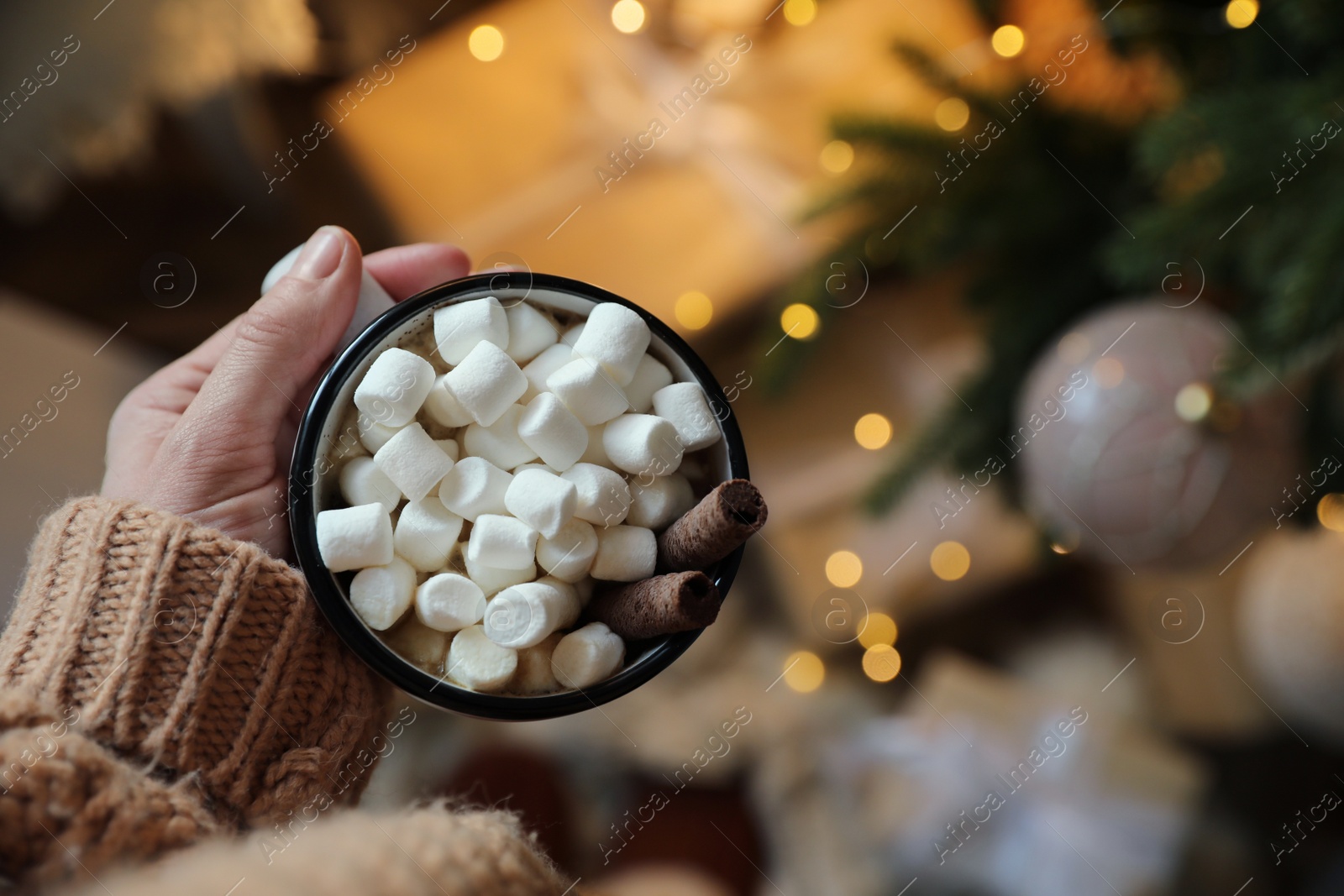 Photo of Woman with cup of cocoa indoors, top view. Christmas mood