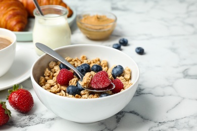 Photo of Tasty breakfast with muesli served on white marble table