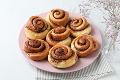 Photo of Many tasty cinnamon rolls on white table, closeup