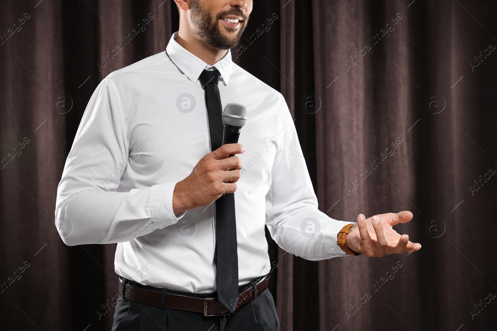 Photo of Motivational speaker with microphone performing on stage, closeup