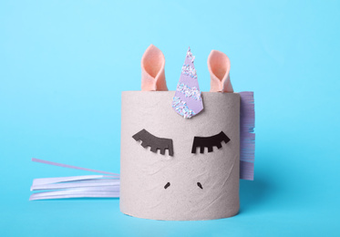 Photo of Toy unicorn made of toilet paper roll on light blue background