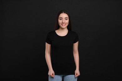 Woman wearing black t-shirt on dark background