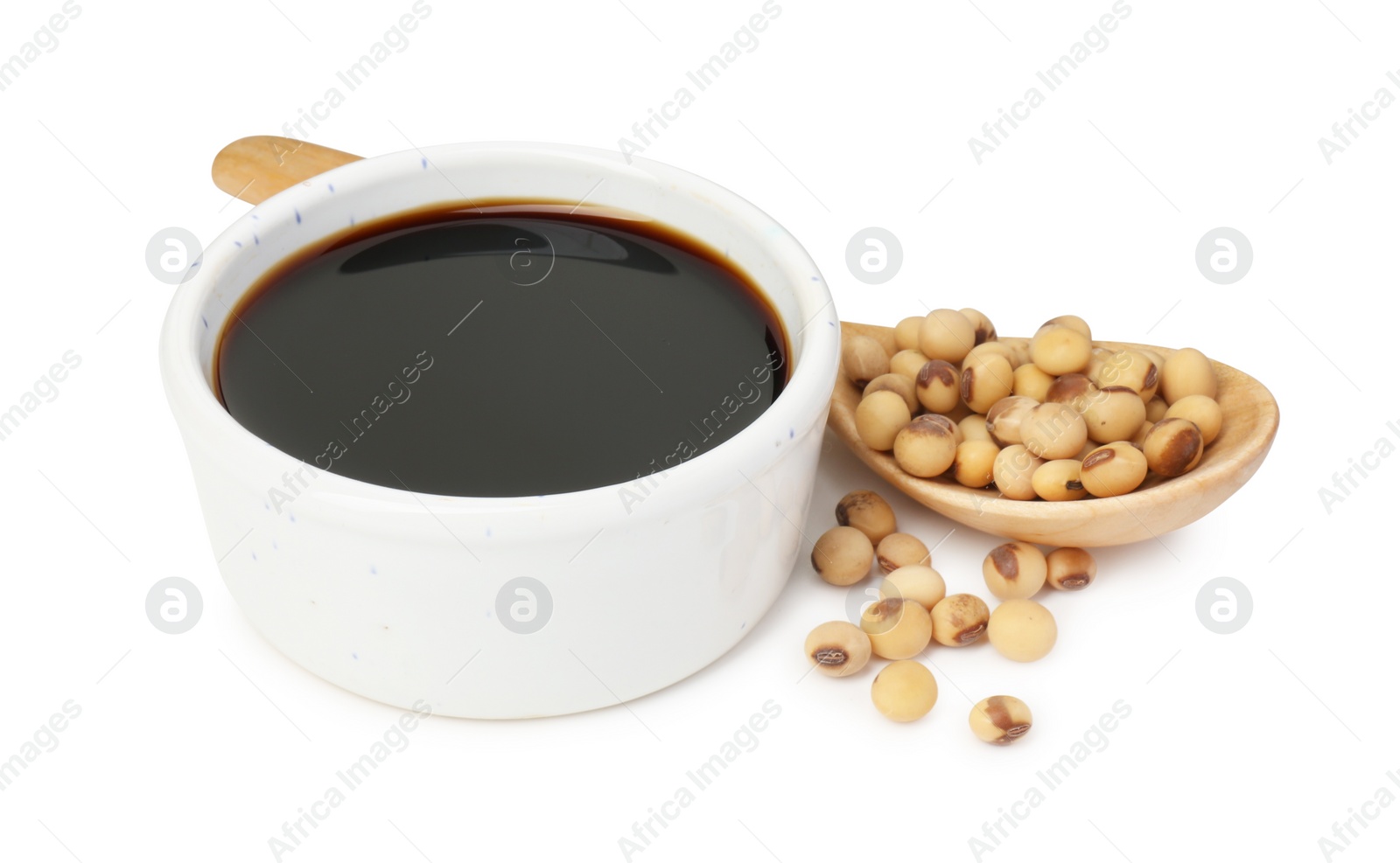 Photo of Tasty soy sauce in bowl, soybeans and spoon isolated on white