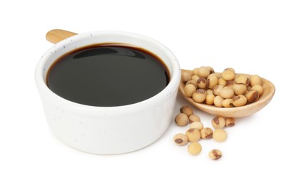 Tasty soy sauce in bowl, soybeans and spoon isolated on white