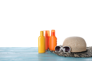 Sun protection products and beach accessories on blue wooden table against white background. Space for text