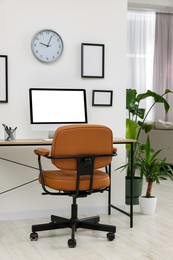 Photo of Stylish room interior with comfortable office chair, desk and houseplants