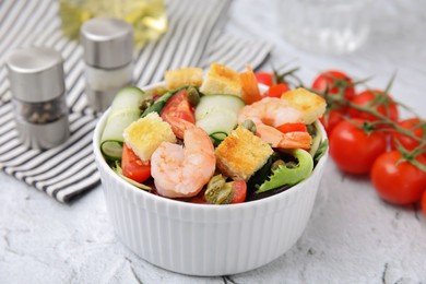 Tasty salad with croutons, tomato and capers on white textured table, closeup