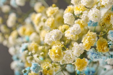 Photo of Many beautiful dyed gypsophila flowers on dark grey background, closeup