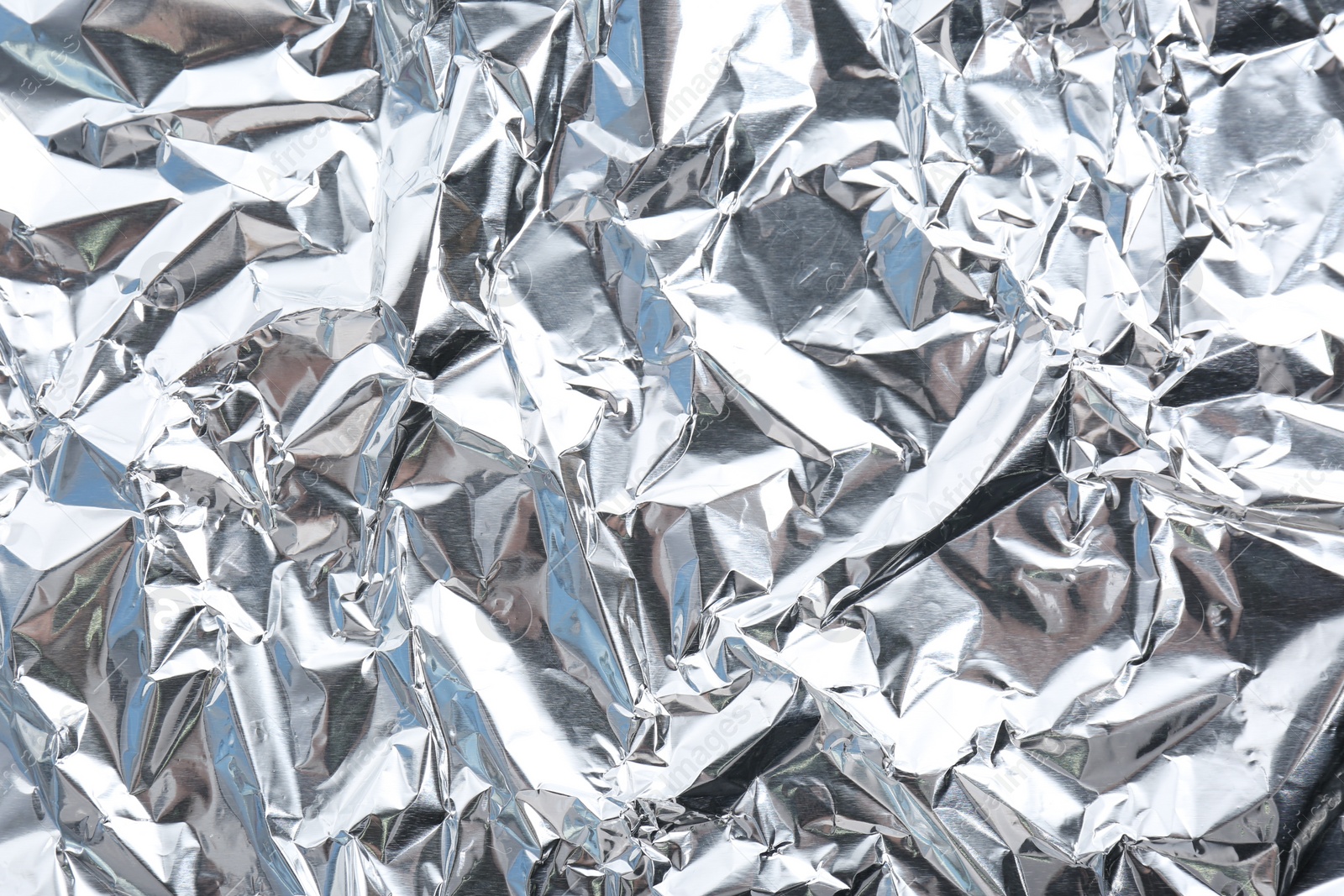 Photo of Crumpled silver foil as background, closeup view