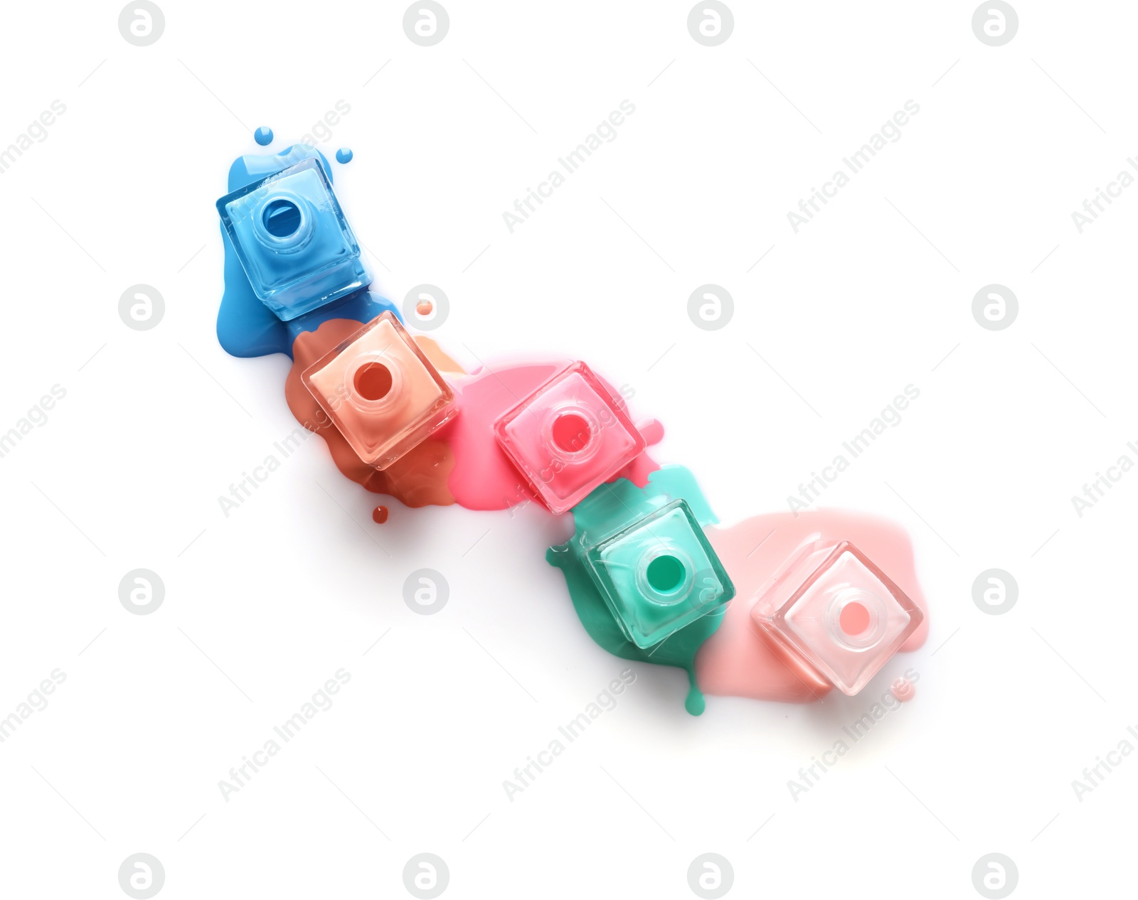 Photo of Spilled different nail polishes with bottles on white background, top view