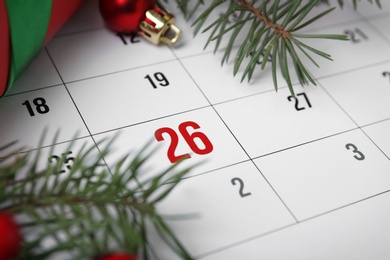 Photo of Gift and fir branches on calendar, closeup. Boxing Day