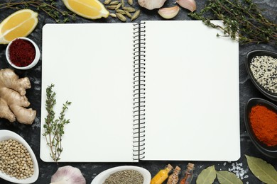 Photo of Blank recipe book surrounded by different ingredients on black textured table, flat lay. Space for text