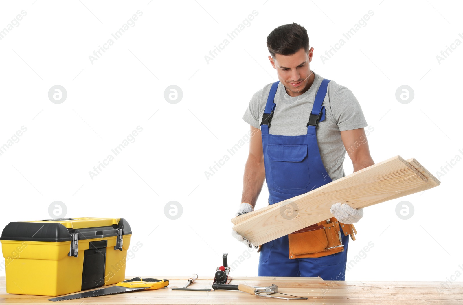 Photo of Handsome carpenter working with timber at wooden table on white background