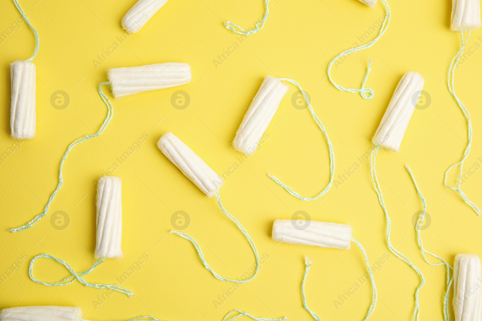 Photo of Tampons on yellow background, flat lay. Menstrual hygiene product