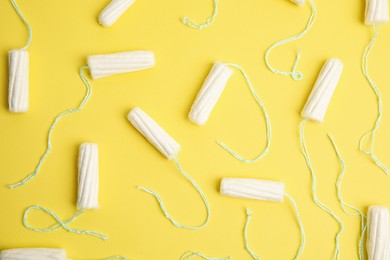 Photo of Tampons on yellow background, flat lay. Menstrual hygiene product