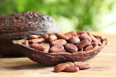 Photo of Cocoa pod with beans on wooden table