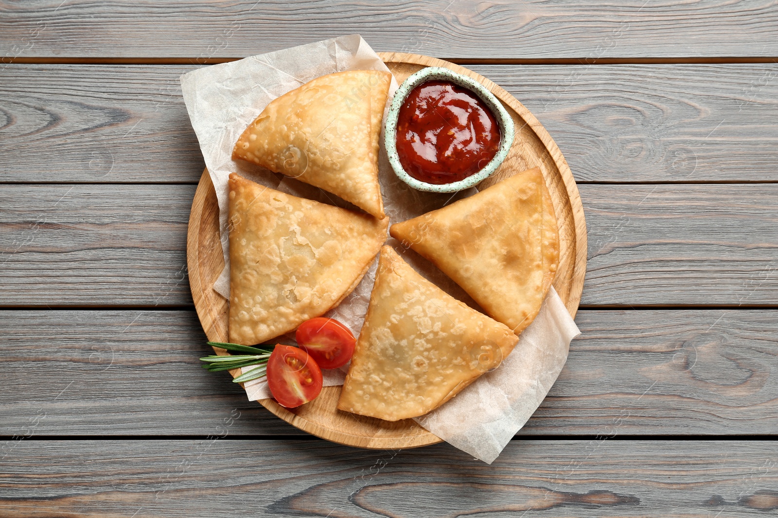 Photo of Fresh delicious crispy samosas served on wooden table, top view