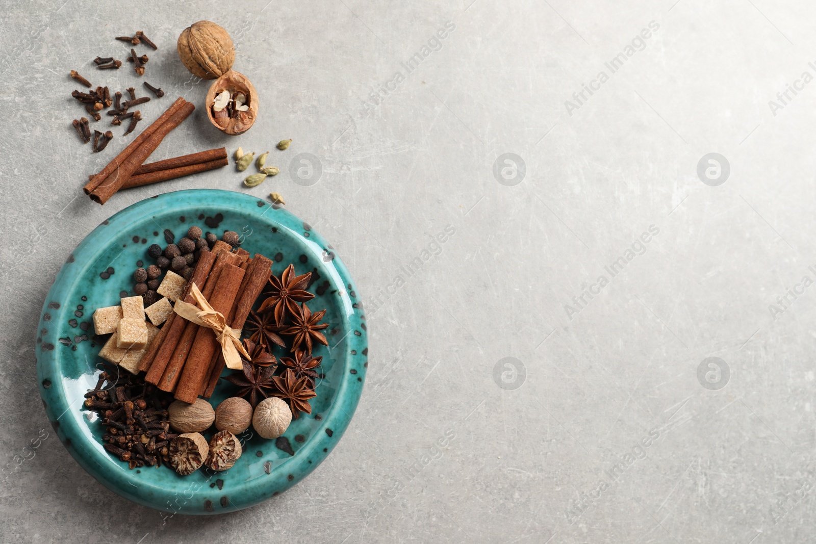 Photo of Different aromatic spices on light textured table, flat lay. Space for text