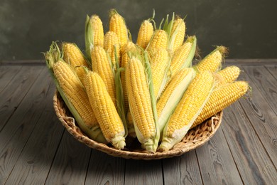 Tasty sweet corn cobs on wooden table