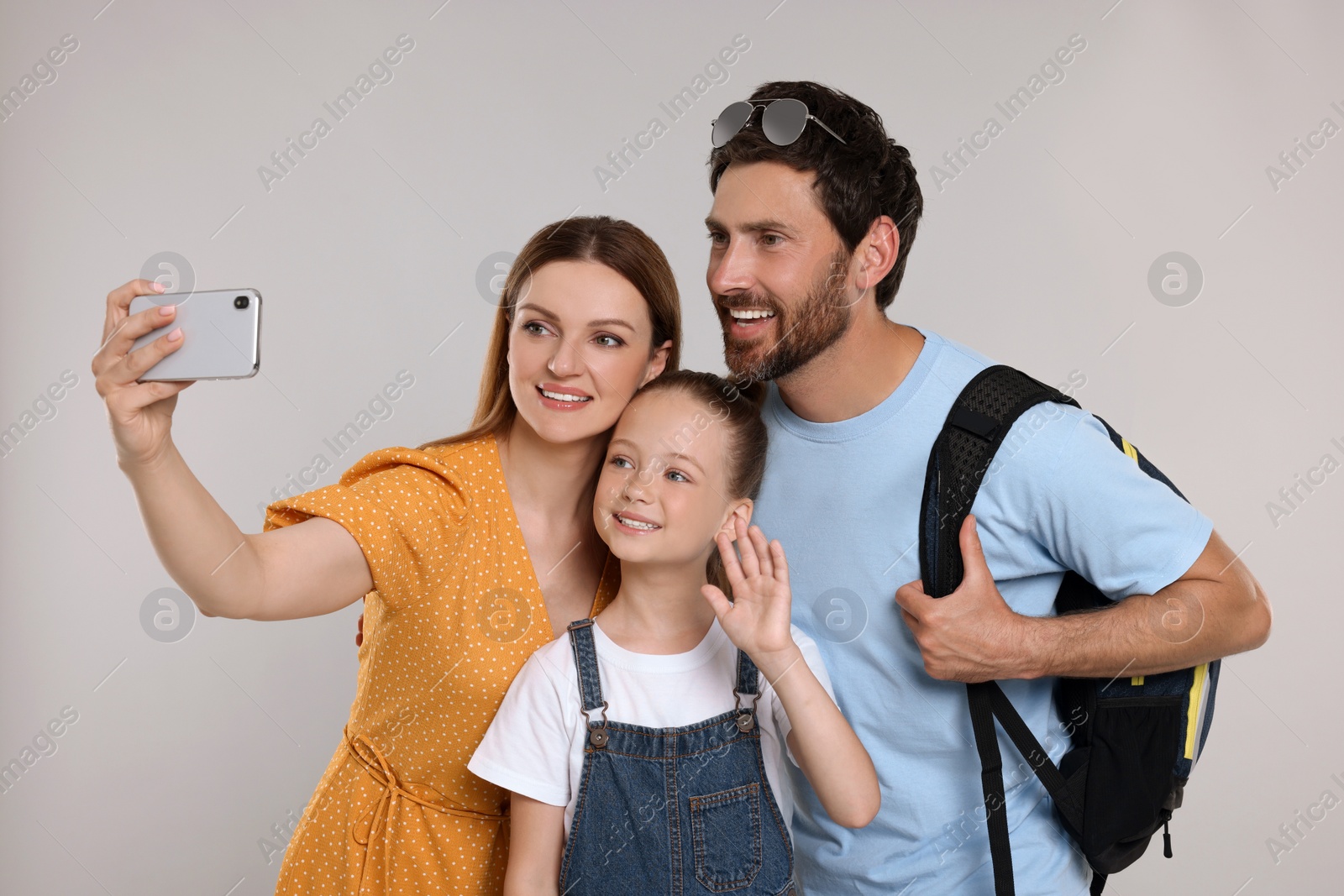 Photo of Happy family taking selfie on light grey background