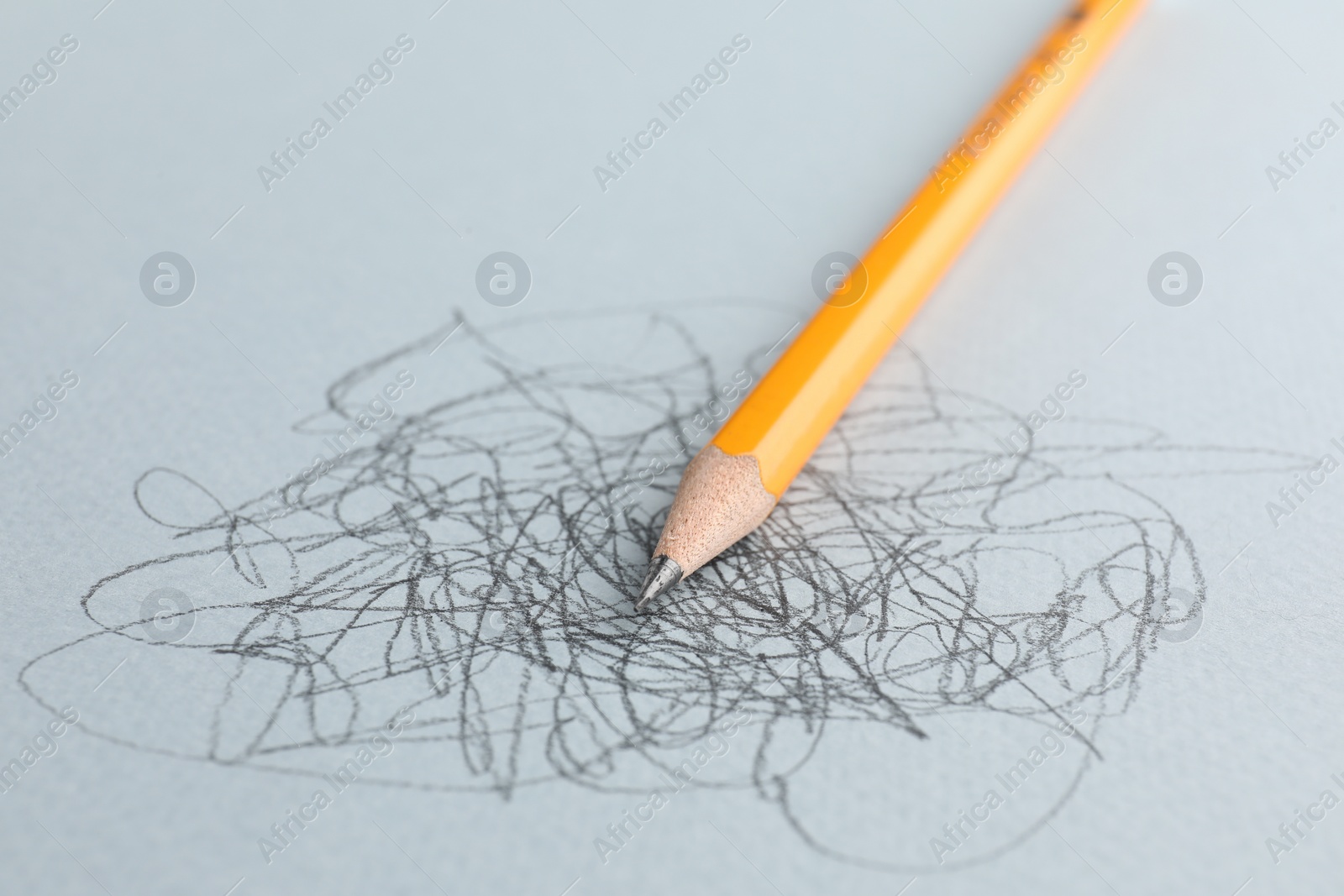 Photo of One sharp graphite pencil and scribbles on white background, closeup
