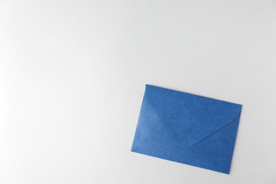 Photo of Blue paper envelope on light background, top view. Space for text