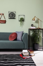 Photo of Stylish interior with comfortable sofa and cushions near console table