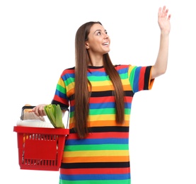 Young woman with shopping basket full of products isolated on white