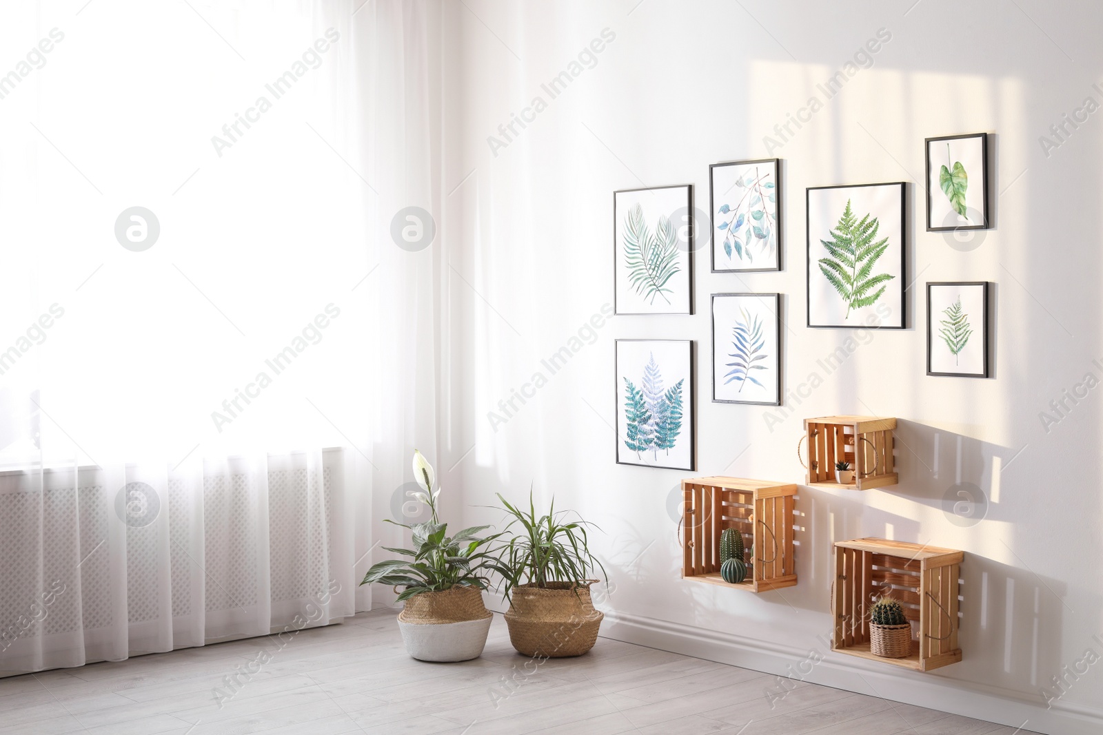 Photo of Beautiful paintings of tropical leaves on white wall in living room interior