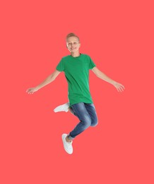 Image of Teenage boy jumping on red background, full length portrait