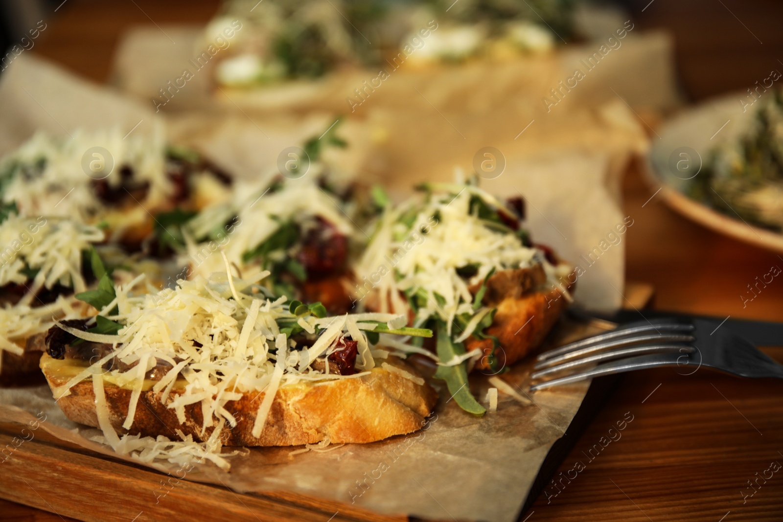 Photo of Delicious bruschettas with beef and cheese on wooden table, closeup