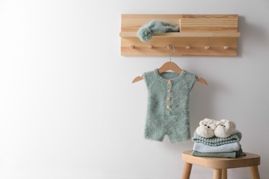 Photo of Cute children's clothes and shoes in room. Space for text