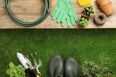 Flat lay composition with gardening tools and plants on green grass, space for text