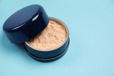 One face powder on light blue background, space for text