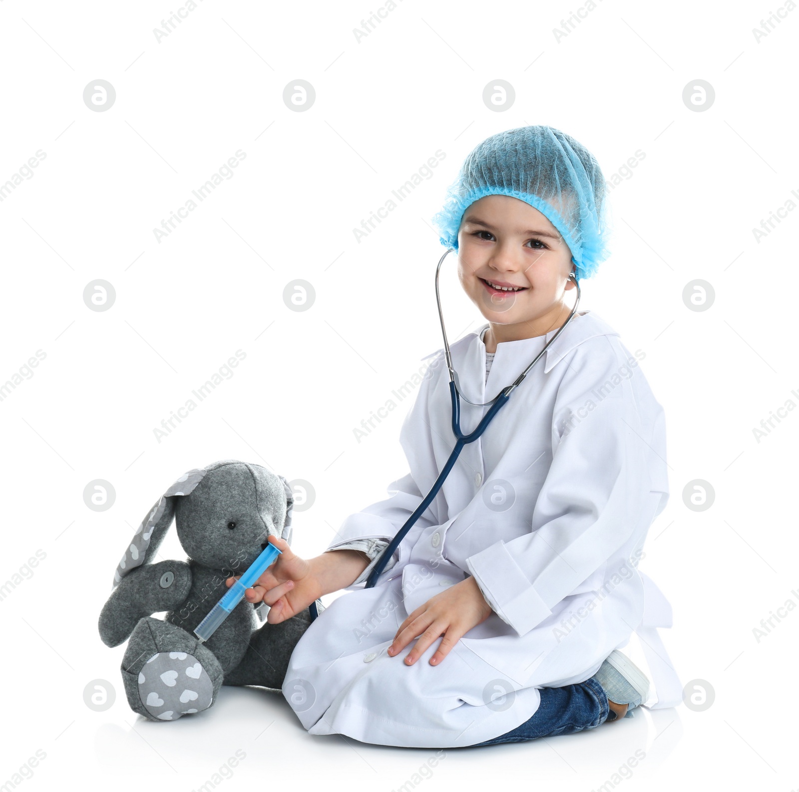 Photo of Cute child playing doctor with stuffed toy on white background