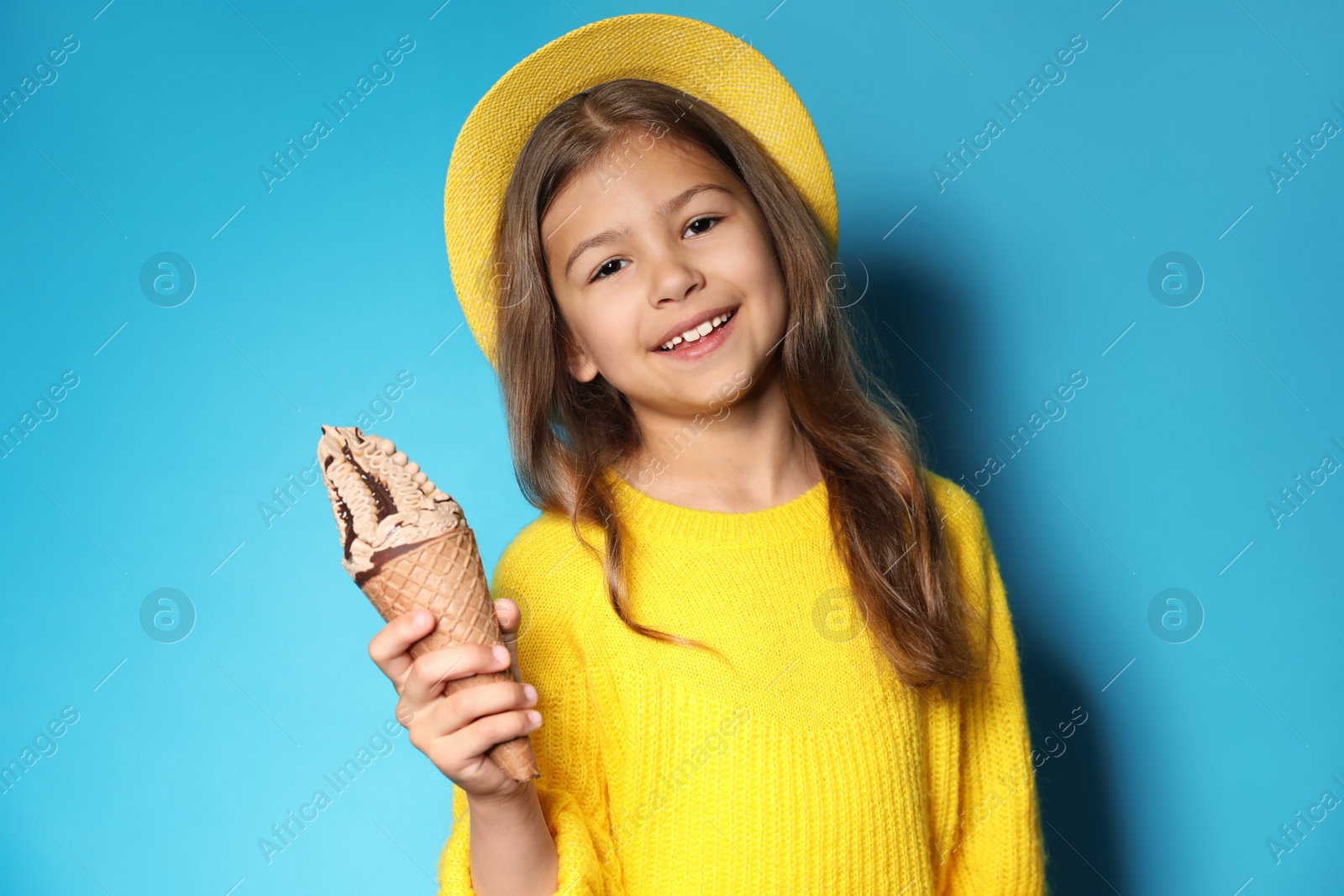 Photo of Adorable little girl with delicious ice cream against color background