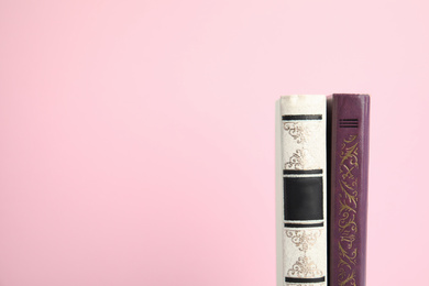 Photo of Old books on pink background, space for text