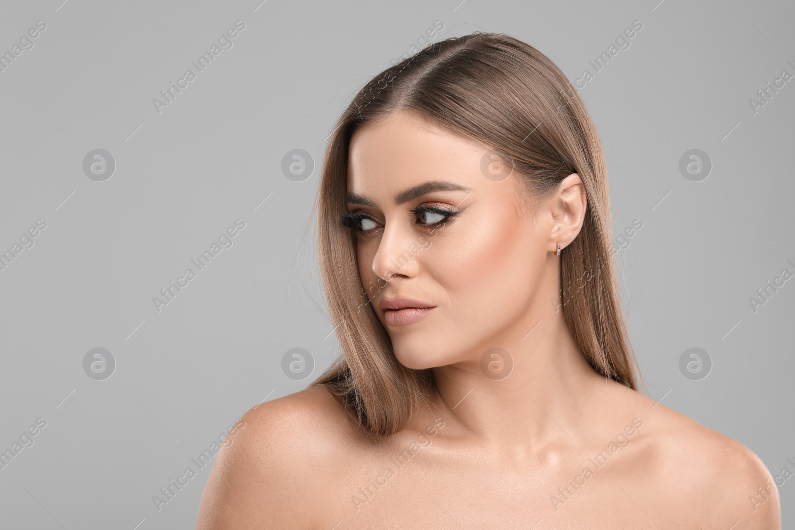Photo of Beautiful woman with makeup on grey background, space for text