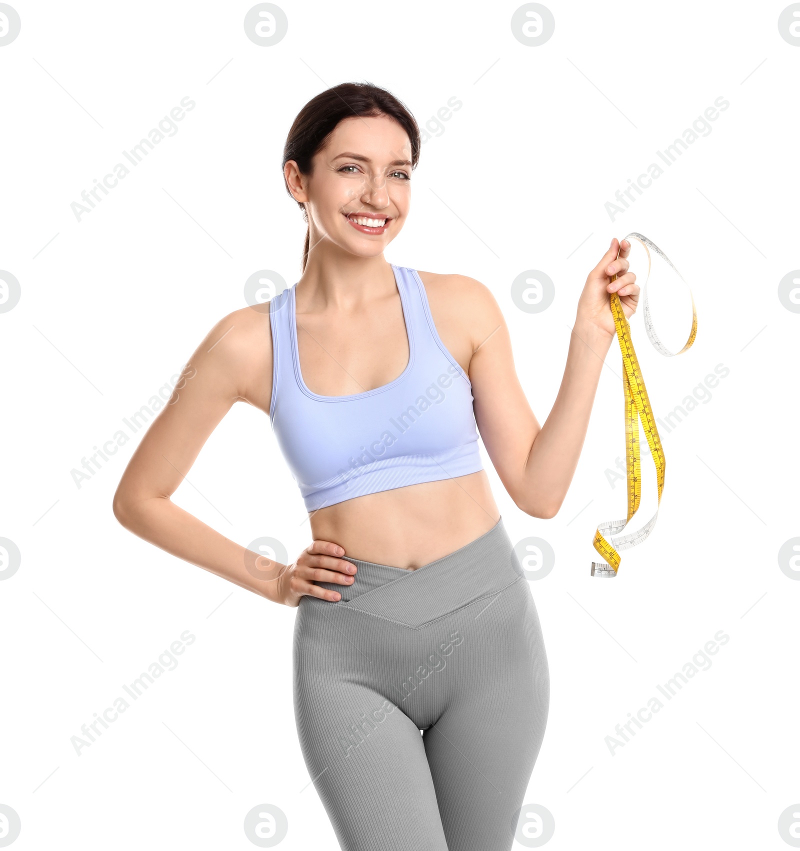 Photo of Happy young woman with measuring tape showing her slim body against white background