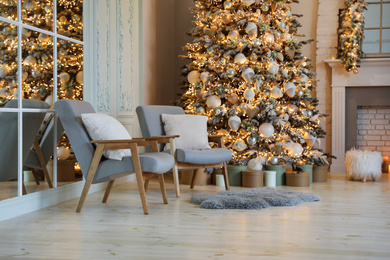 Festive room interior with stylish furniture and beautiful Christmas tree