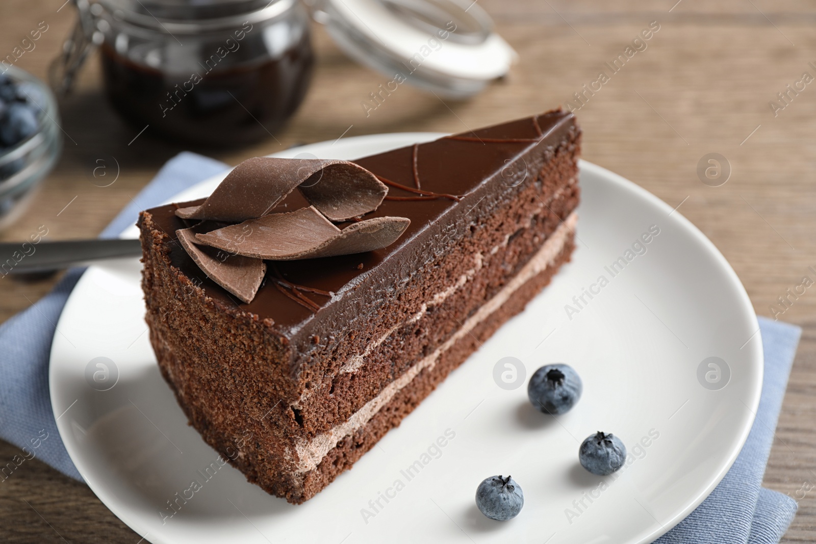 Photo of Delicious fresh chocolate cake on wooden table, closeup