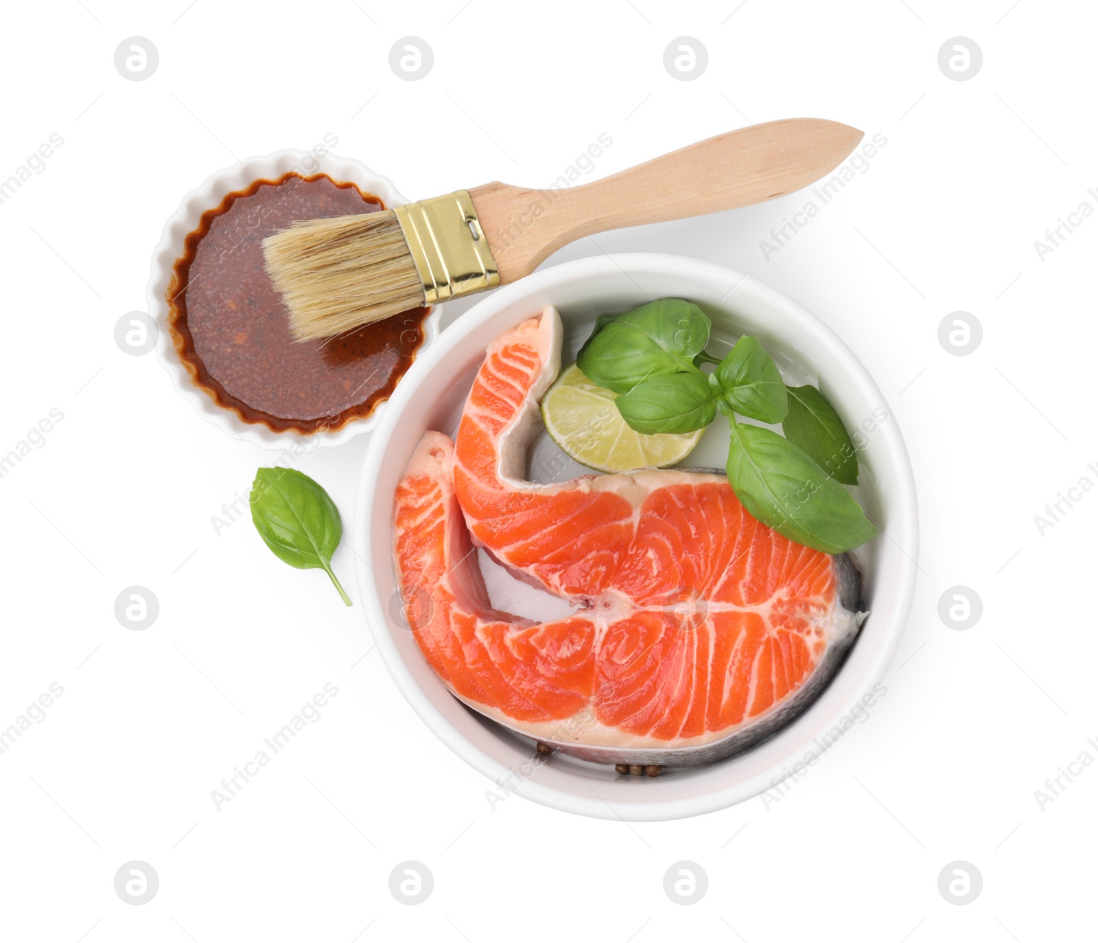 Photo of Fresh marinade, fish, lime, basil and brush isolated on white, top view