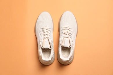 Photo of Pair of stylish sport shoes on orange background, flat lay