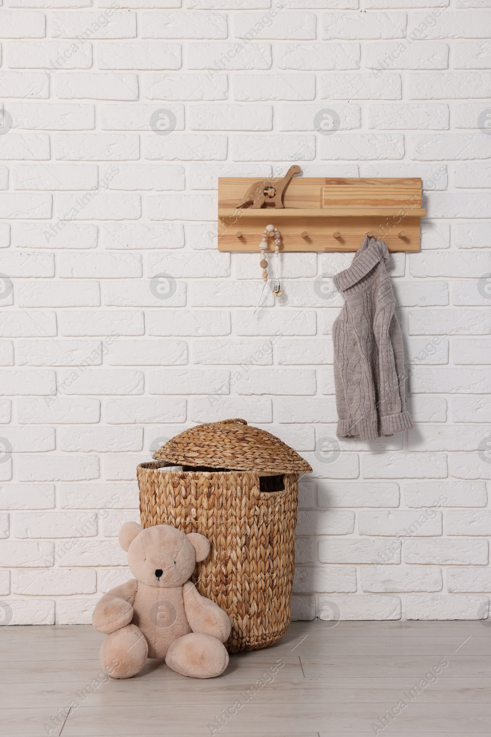 Photo of Beautiful children's room with white brick wall and toys. Interior design