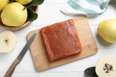 Photo of Delicious quince paste and fresh fruits on white wooden table, flat lay