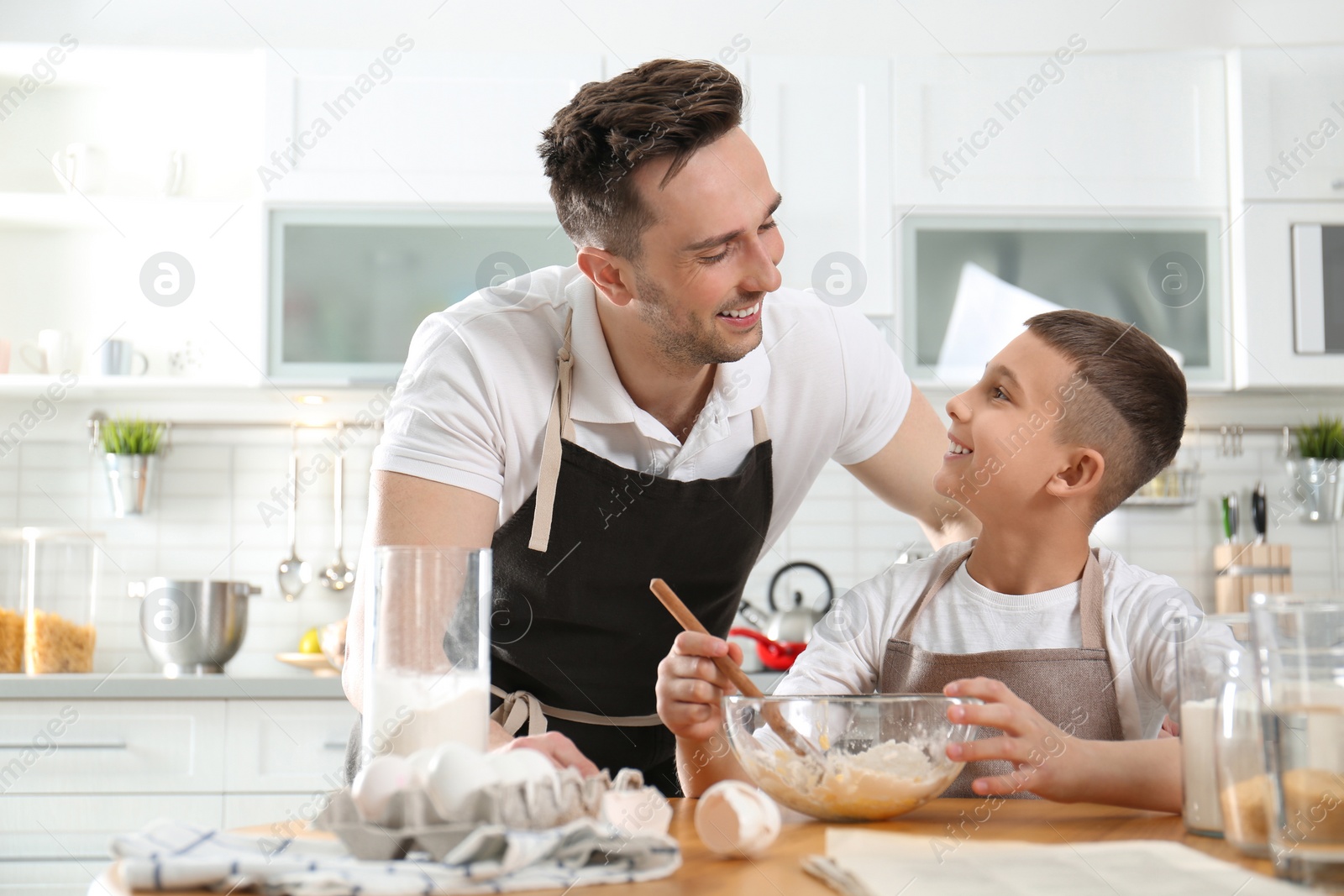 Photo of Dad and son cooking together in kitchen